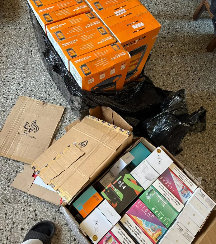 Caja abierta con vapes y auriculares junto a calefactores